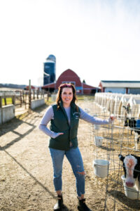 Annaliese Wegner - Modern Day Farm Chick - Wisconsin Dairy Farmer standing in front of calf hutches