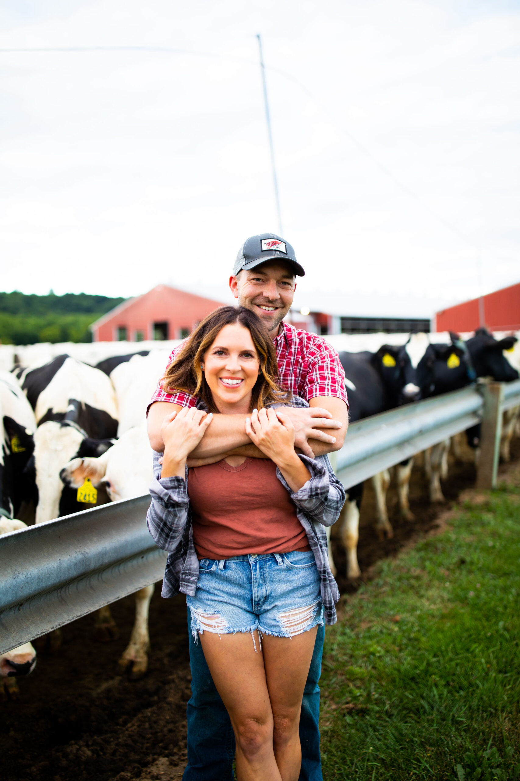 Wisconsin dairy farm couple in front of cows on the farm