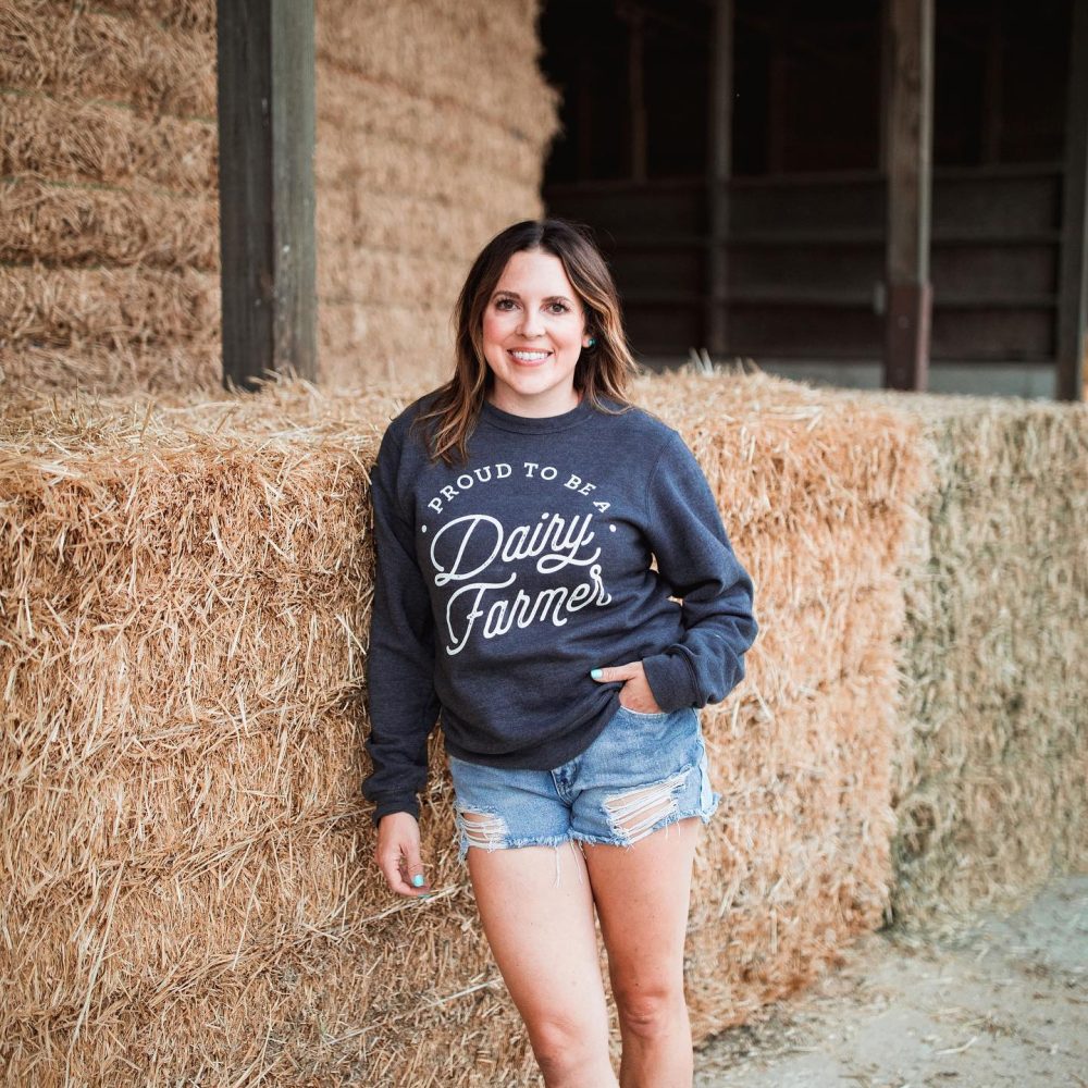 Annaliese Wegner - proud to be a dairy farmer in front of straw bales